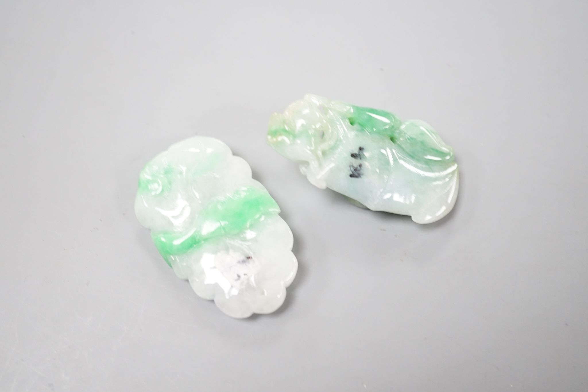 Two carved jade pendants, largest 45mm.